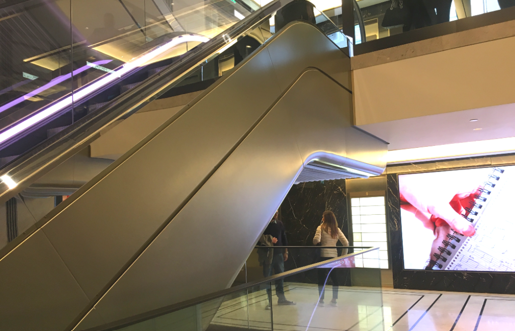 Sustainable metal finish in champagne used on escalator cladding in a luxury retail environment
