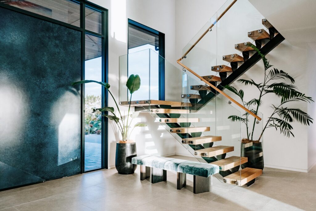 Modern interior showcasing a Metalier liquid metal door and an open-tread staircase in a bright residential entryway – Los Angeles.