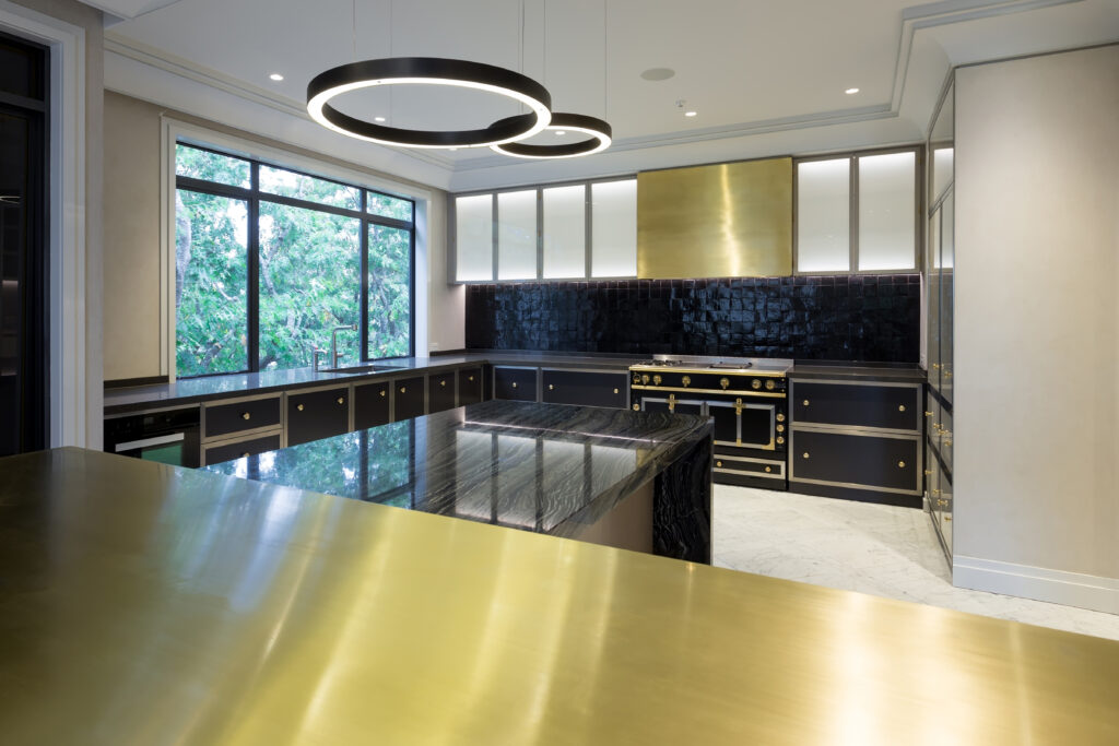 Metalier liquid metal classic gold finish on a custom range hood and kitchen island countertop in a luxury residence – Florida.