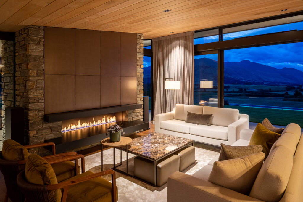 Metalier liquid metal fireplace feature wall with linear flame in contemporary living room overlooking mountain landscape at dusk – New Zealand