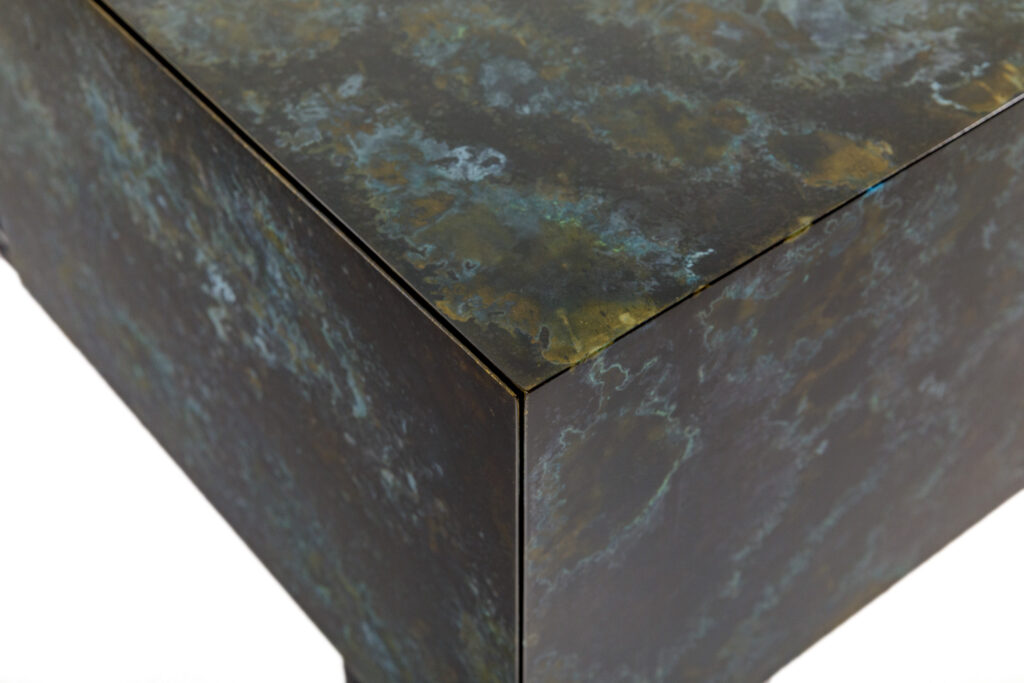Close-up of patinated metal cube with oxidized bronze and blue-green finish – contemporary bespoke furniture detail in Sydney, Australia.