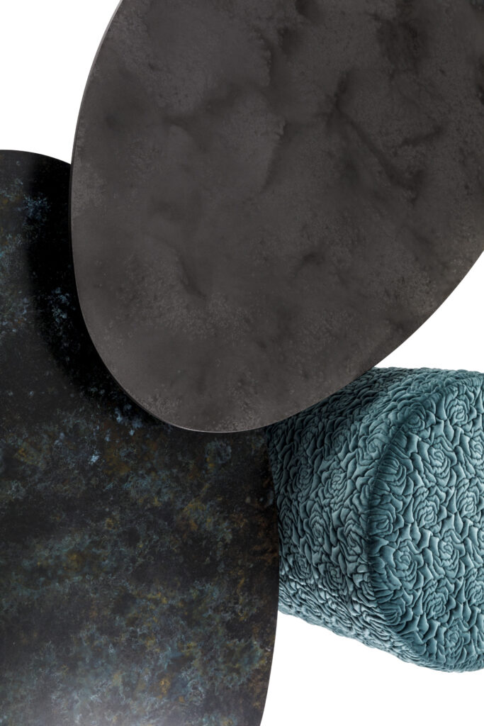 “Abstract textured metal discs with oxidized patina finish paired with teal quilted cylindrical cushion – contemporary interior design - London