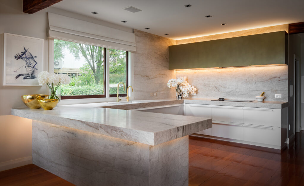 Metalier liquid metal olive gold finish on a custom range hood in a luxury kitchen with marble countertops and backsplashes – Sydney.