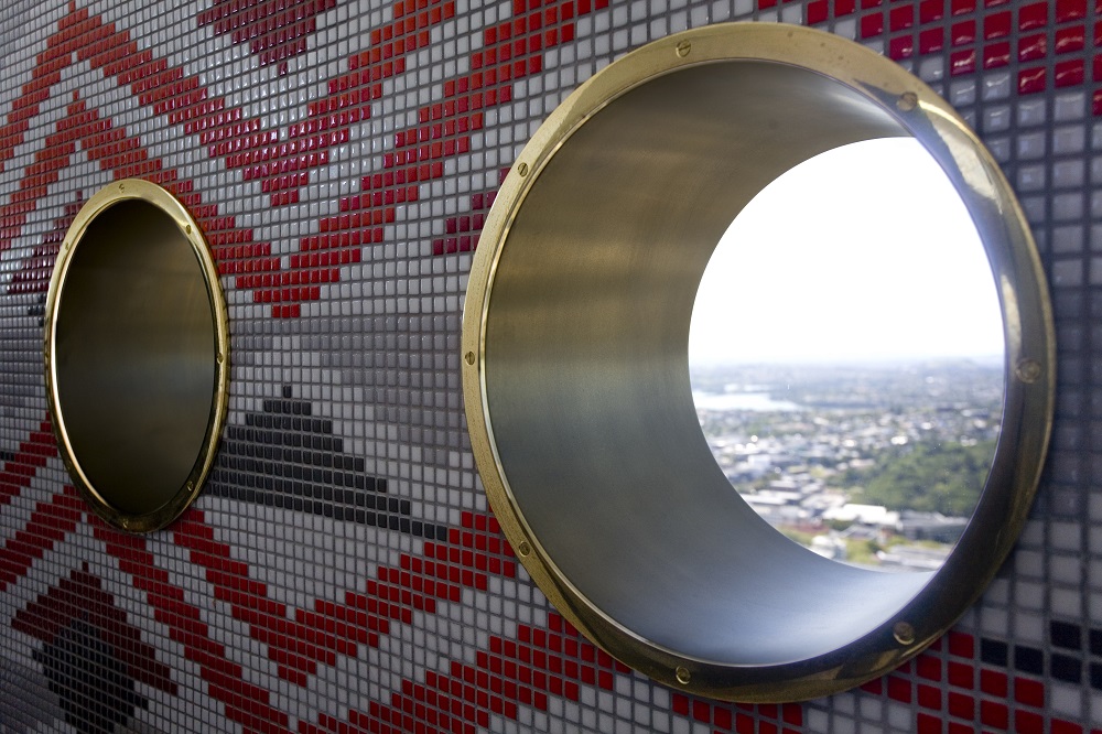 Close up of sheet brass porthole rims beside a Metalier real metal coating finish