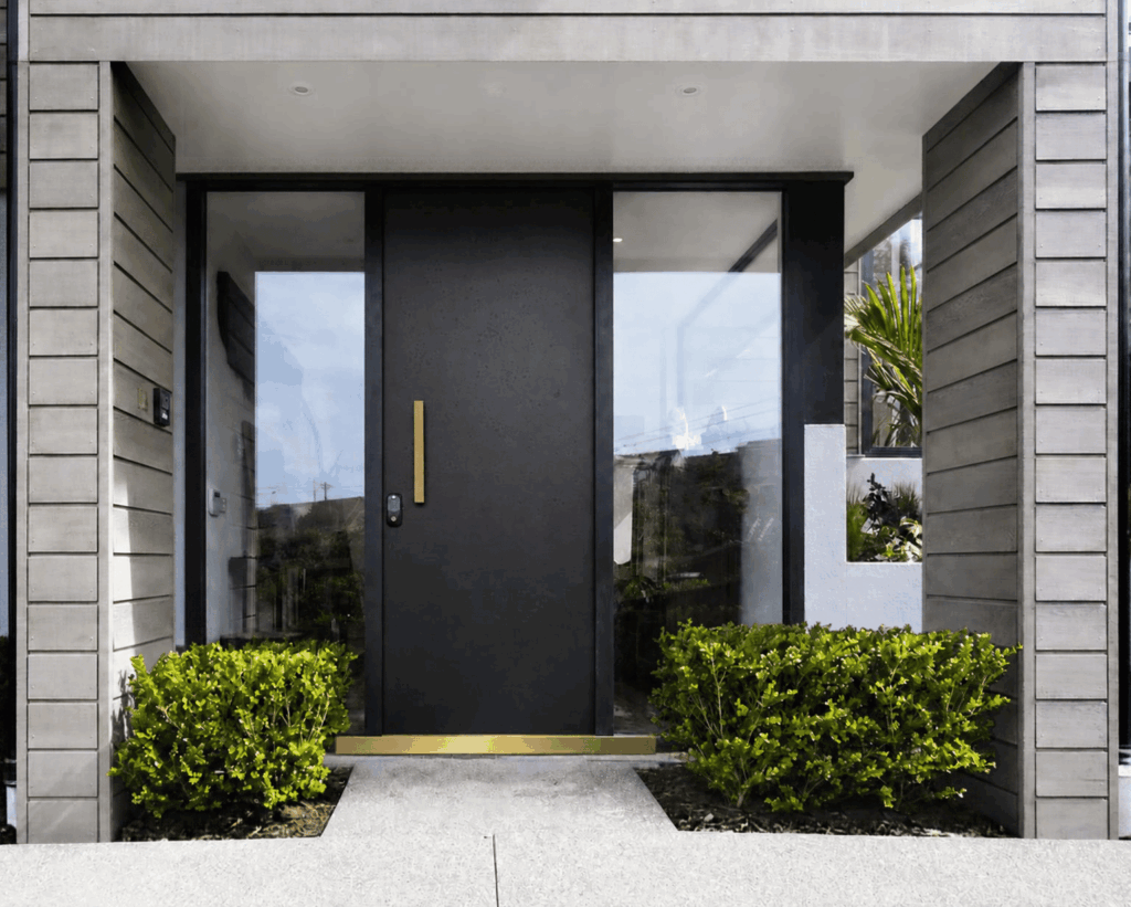 Black front door with polished brass footplate, illustrating a metal surface that could benefit from protective clear coating.
